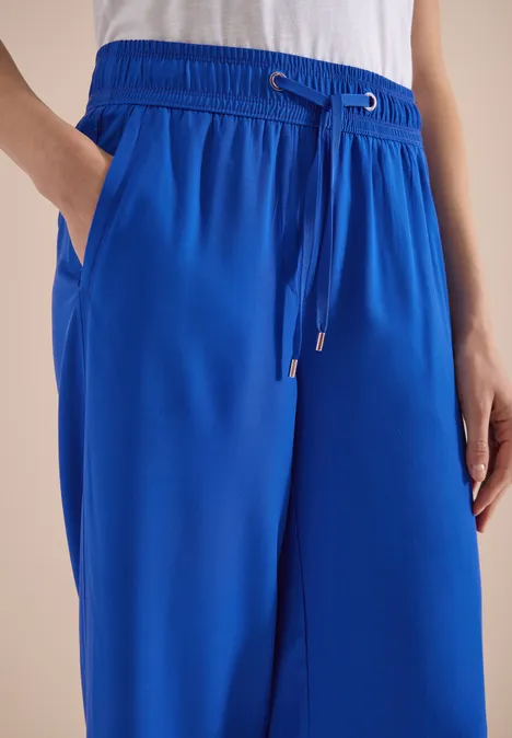Loszittende koningsblauwe broek met elastische taille, koordsluiting en zijzakken.