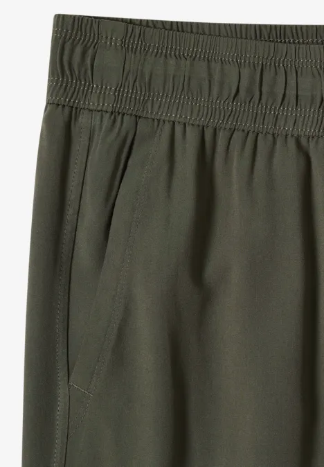 Pantalon vert olive à taille élastique avec poche latérale.