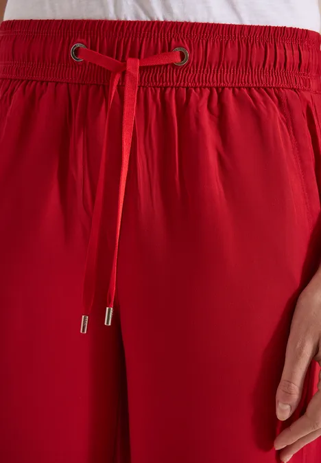 Rode broek met elastische taille en aantrekkoord, detailweergave.
