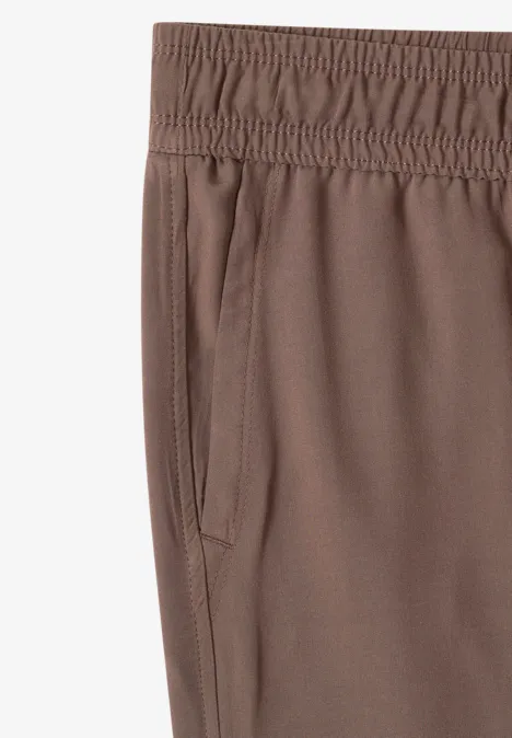 Bruine sportbroek met elastische taille en zijzak.