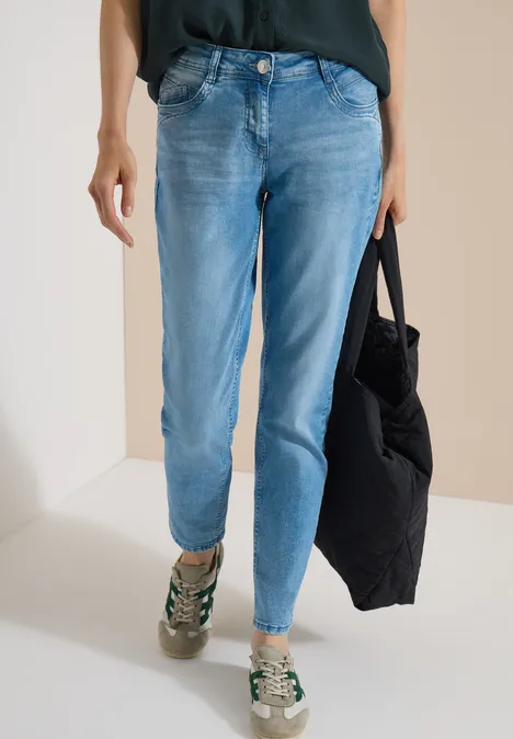 Jean taille moyenne, coupe Slim Leg et style décontracté light blue wash Bas du corps en jean bleu clair, baskets et sac noir.