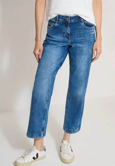 Jean à jambes larges avec des bandes en galon mid blue wash Une personne porte un jean bleu droit et des baskets blanches.