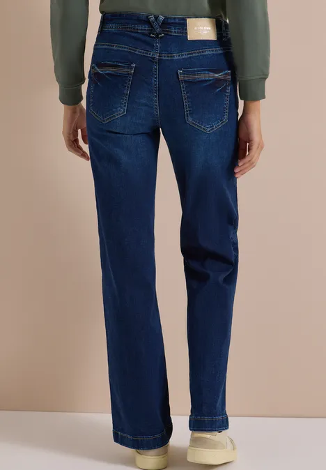 Rückansicht: Dunkelblaue Damenjeans mit geradem Schnitt, zwei Gesäßstaschen und weißen Sneakern.