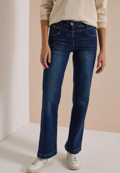 Dunkelblaue, gerade geschnittene Jeans mit weißen Sneakern