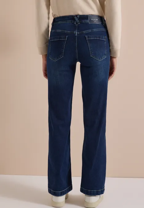 Rückansicht einer Person in hochgesitzender, dunkelblauer Jeans mit weitem Bein und umgeschlagenem Saum.