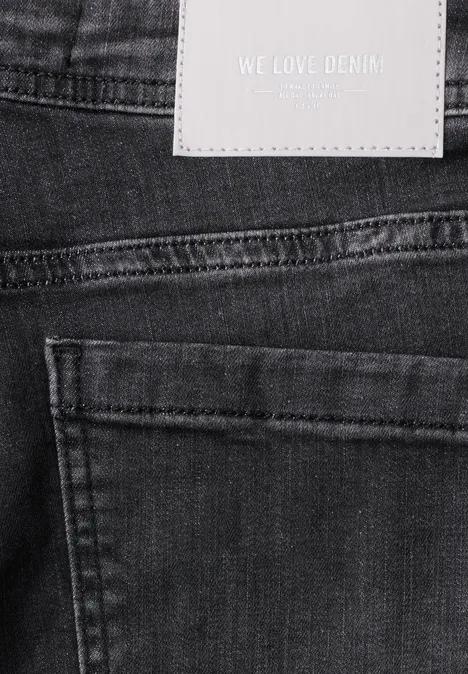 Zwart denimstof met zak en wit label 'WE LOVE DENIM'.