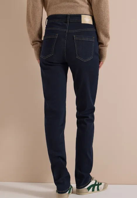 High Waist Slim Leg Jeans Slim Fit rinsed wash Eine Person trägt dunkle Jeans, Rückansicht, bequeme Schuhe