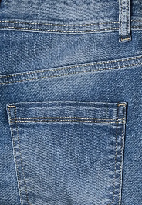Mid Waist Slim Leg Jeans im Casual Fit mid blue wash Nahaufnahme von blauer Jeans mit erkennbarer Gesäßtasche und Nahtdetails.