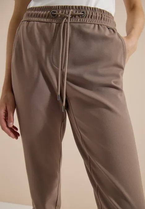 Mid Waist Slim Leg Hose im Casual Fit earthy taupe Braune Jogginghose mit elastischem Bund, Tunnelzug und seitlichen Taschen.