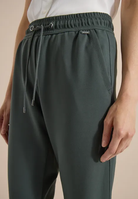 Donkergroene joggingbroek met trekkoord, elastische taille en zijzakken.