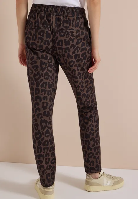 Mid Waist Slim Leg Hose w Casual Fit dark toffee brown Osoba widziana od tyłu w dopasowanych brązowych legginsach w panterkę i jasnych trampkach.