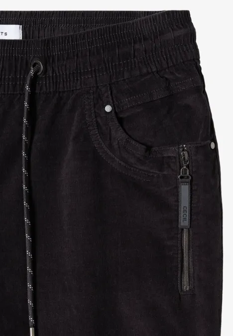 Pantalon de jogging noir en velours côtelé, taille élastique, cordon et poche latérale zippée.