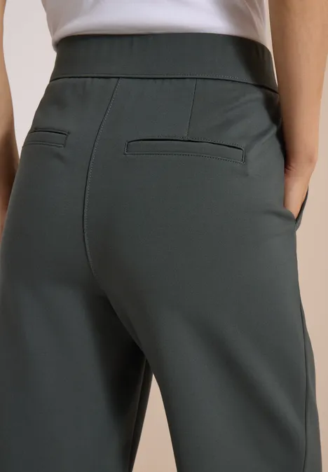 Vue de dos d'une personne portant un pantalon gris taille haute avec poches