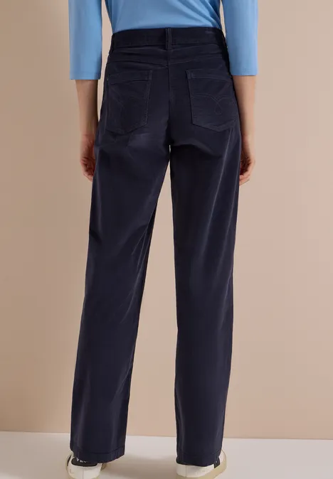 Vue de dos d'une personne portant un pantalon en velours côtelé bleu foncé et un haut bleu clair.