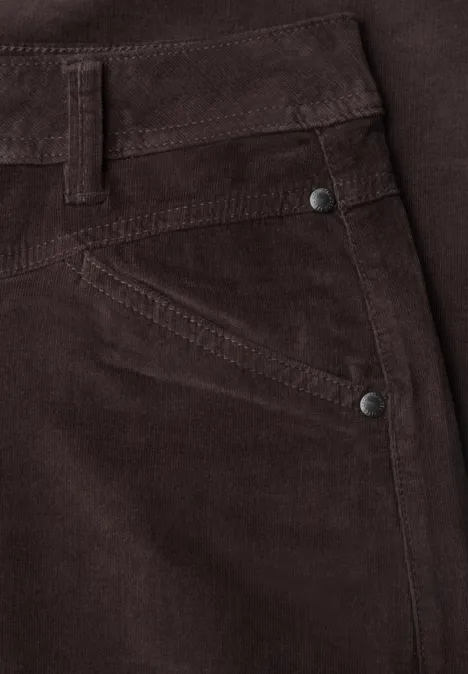 Nahaufnahme einer braunen Cordhose mit Tasche und Metallnieten.