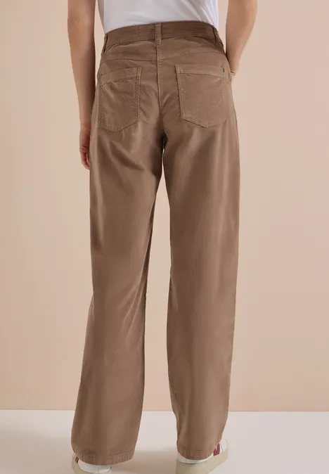 Vue arrière d'une personne portant un pantalon en velours côtelé beige-brun ample sur fond neutre.