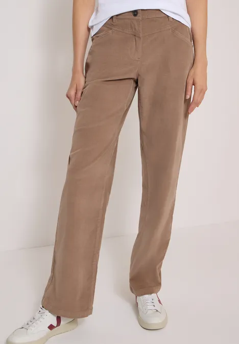 Pantalon marron droit, porté avec des baskets blanches et un haut blanc.