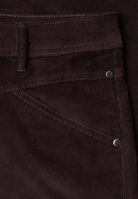Makroaufnahme einer dunkelbraunen Cordhose mit sichtbaren Nähten, Gürtelschlaufe und Tasche.