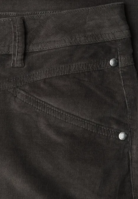 Nahaufnahme einer dunkelbraunen Cordhose mit Tasche, Gürtelschlaufe und silbernen Nieten.