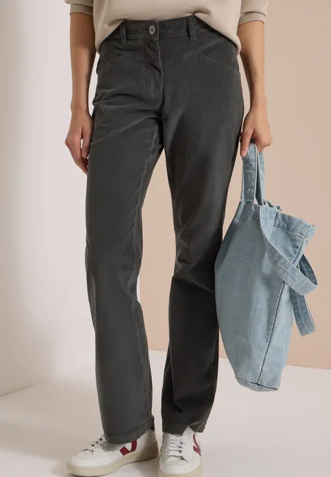 Pantalon droit gris, baskets blanches à détails rouges et sac fourre-tout en denim bleu clair.