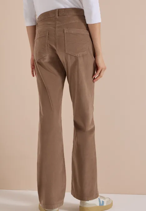 Pantalon marron droit avec poches, haut blanc et baskets.