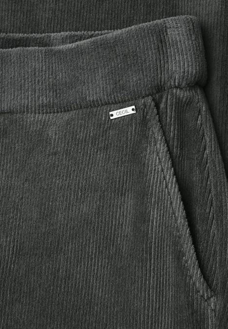 High Waist Straight Leg Hose w kroju Loose Fit easy khaki Zbliżenie szarych spodni sztruksowych z elastycznym pasem i boczną kieszenią z małą metalową oznaką.
