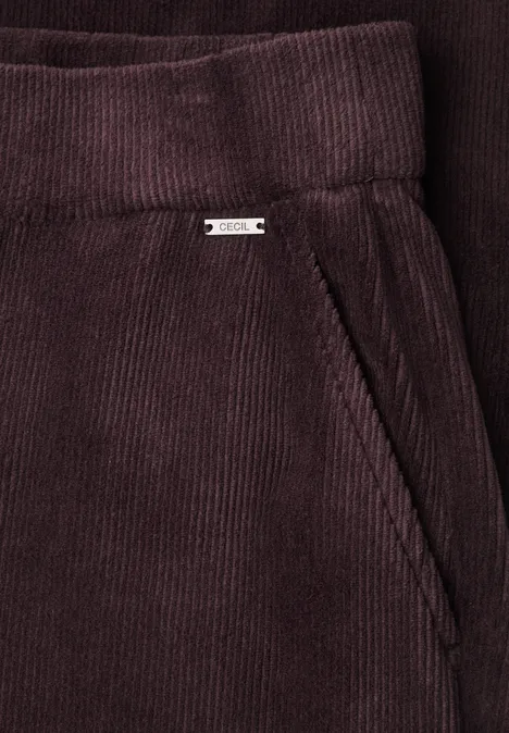 Nahaufnahme einer dunkelvioletten Cordhose mit Seitentasche und Gürtelbund.