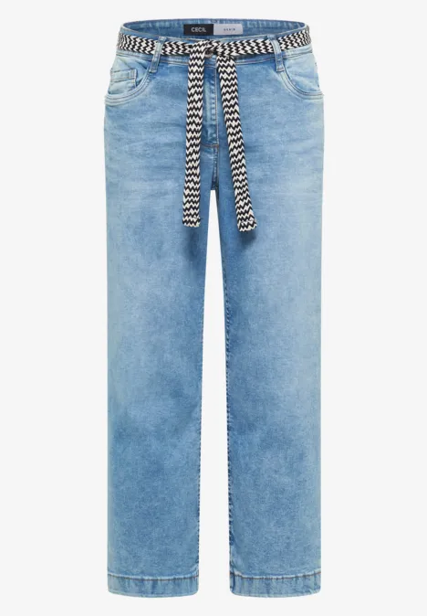 Jean droit bleu clair avec ceinture tressée noir et blanc nouée à la taille.