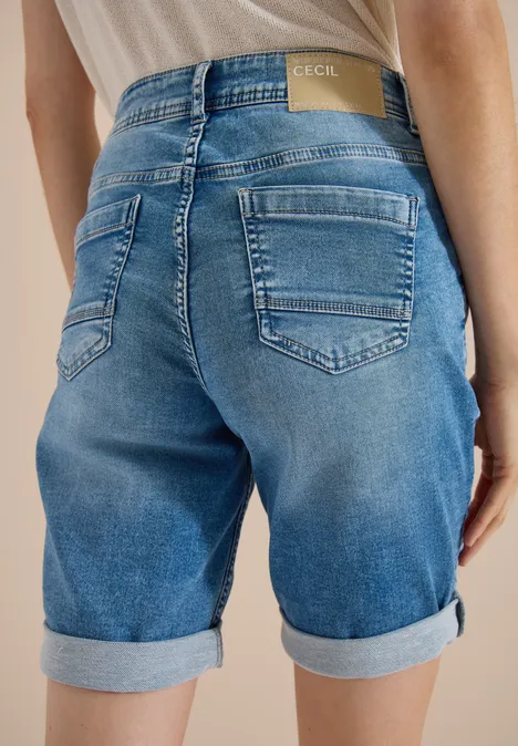 Rückenansicht einer Person in blauen Jeans-Shorts mit hochgekrempeltem Saum
