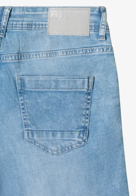 Nahaufnahme einer hellblauen Jeansrückentasche mit Naht und Lederetikett am Bund.