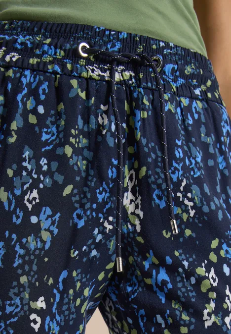Hose mit blau-grünem Leopardenmuster und Kordelzug am Taillenbund.