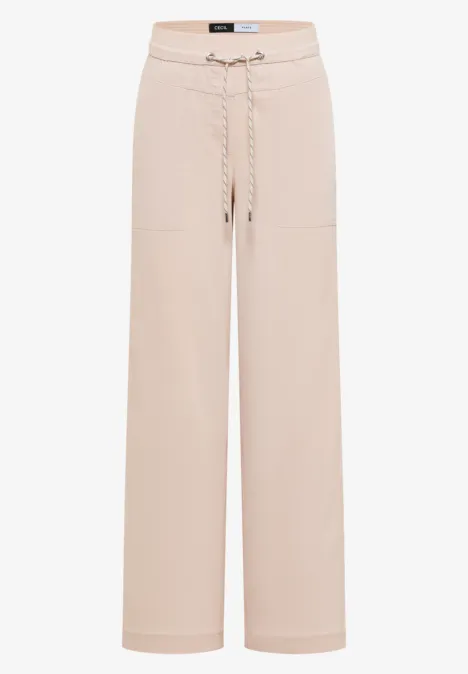 Beige, locker geschnittene Hose mit Kordelzug und aufgesetzten Taschen.
