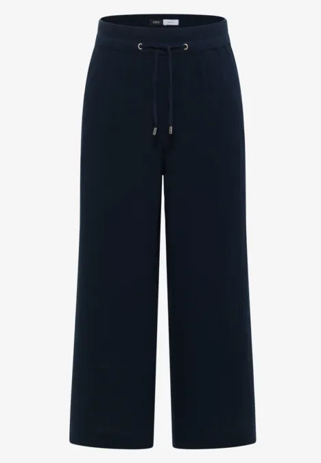 Zwarte, wijde broek met trekkoord in de taille en rechte pijpen.