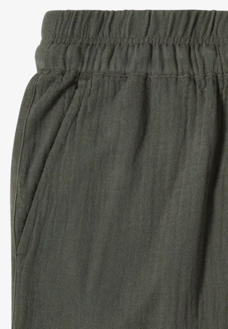 Dunkelgrüne Hose mit Gummibund und Seitentaschen, leicht strukturierter Stoff.