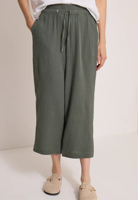Olivgrüne, knöchellange Culotte-Hose mit elastischem Bund und Tunnelzug, aus leichtem, strukturiertem Stoff.