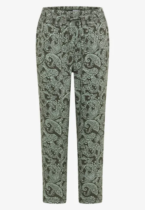 Grüne Stoffhose mit schwarzem Paisley-Muster und schmal zulaufendem Bein.