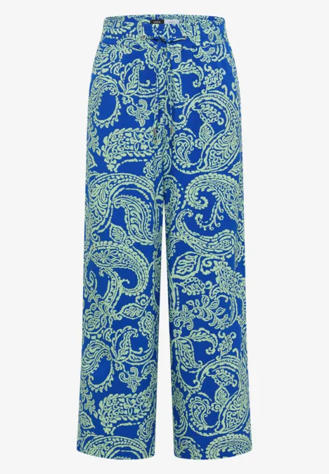Weite Stoffhose in Blau mit hellgrünem Paisley-Muster.