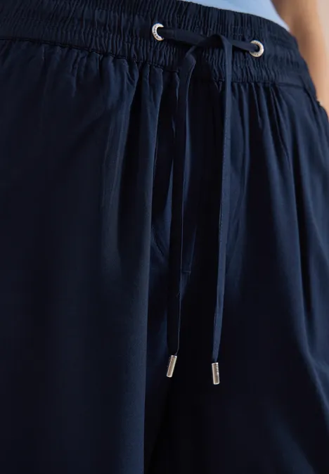 Dunkelblaue, locker sitzende Hose mit Tunnelzug und Kordeln am Bund.