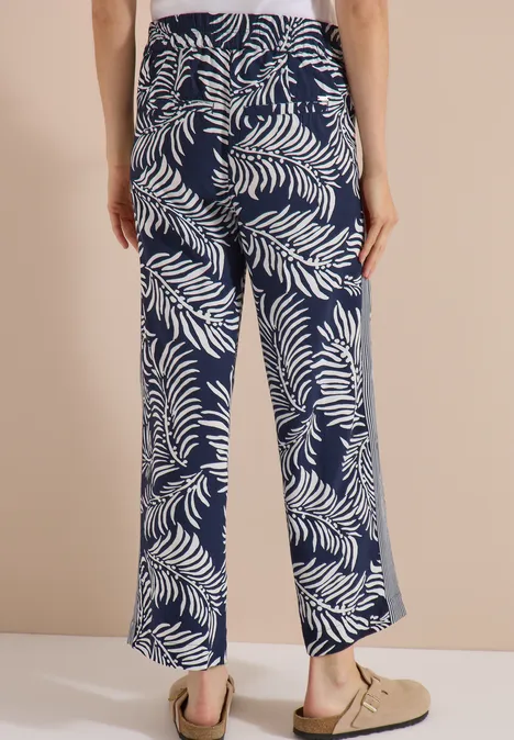 Pantalon à jambes larges avec imprimé et galons universal blue Vue de dos d’un pantalon ample bleu marine à motif de feuilles tropicales blanches.
