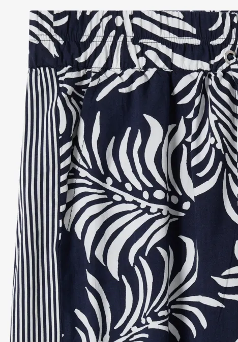 Pantalon à jambes larges avec imprimé et galons universal blue Tissu bleu marine à motif de feuilles blanches avec des rayures contrastées.