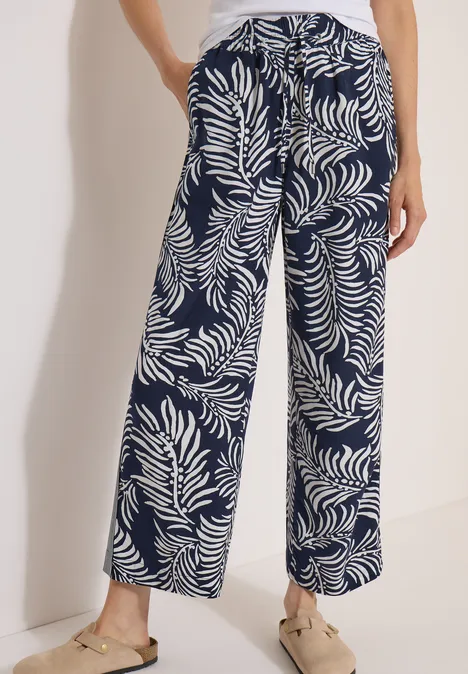Pantalon à jambes larges avec imprimé et galons universal blue Pantalon fluide bleu marine à motif de feuilles blanches, coupe ample et estivale.