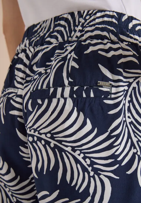 Pantalon à jambes larges avec imprimé et galons universal blue Pantalon bleu marine à motif de feuilles de palmier blanches, taille élastiquée et poche arrière.