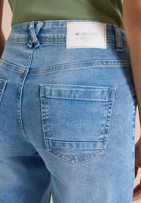 Blick auf den hinteren Teil einer hellblauen Jeanshose mit aufgesetzter Tasche und Markenlabel am Bund.