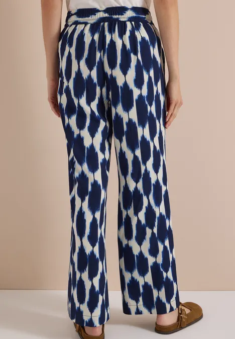 Weite Stoffhose mit blau-weißem geometrischem Muster.