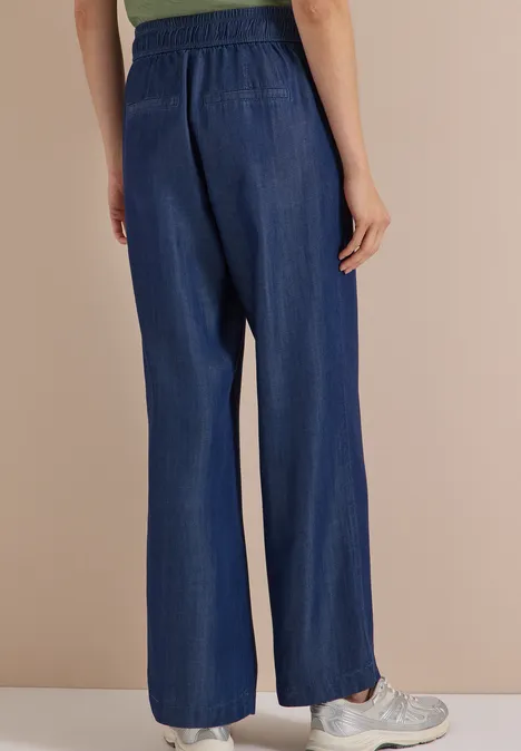Auf dem Bild sind weite, blaue Denim-Hosen mit hohem, elastischem Bund zu sehen.