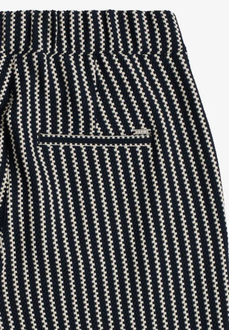 Schwarz-weiße Hose mit Zickzackstreifen und einer kontrastierenden Gesäßtasche.