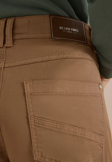 Mid Waist Barrel Leg Hose im Casual Fit creamy mocha Nahaufnahme einer Person in braunen Jeans mit einer Gesäßtasche und Label "We Love Pants".