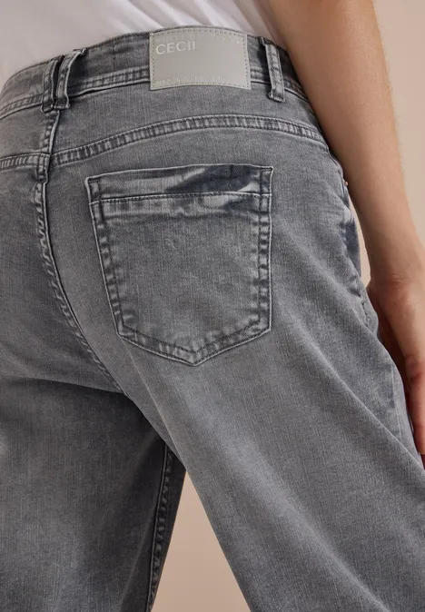 Rückansicht einer Person in grauen Jeans mit Gesäßtasche und markantem CECIL-Label am Bund.