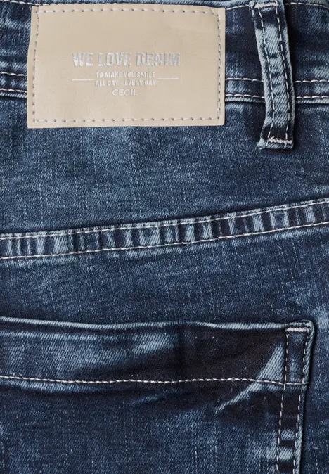 Zbliżenie niebieskich dżinsów z naszywką z eko skóry z napisem "WE LOVE DENIM".