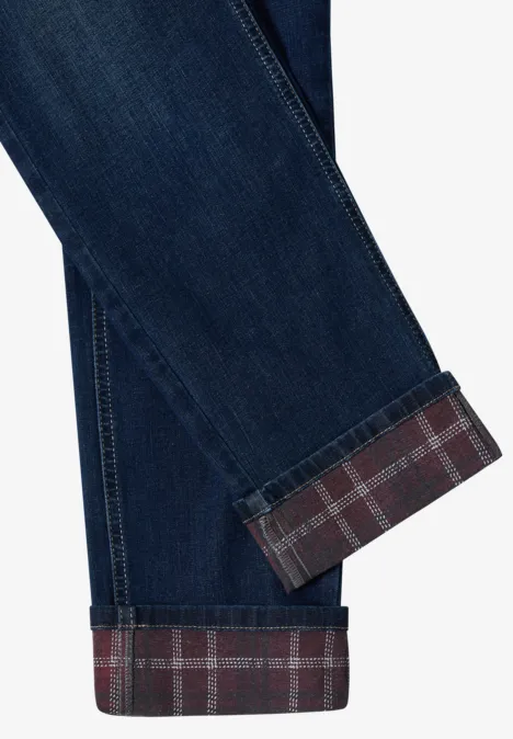 Jambe de jean bleu retroussée dévoilant une doublure intérieure à carreaux rouges.